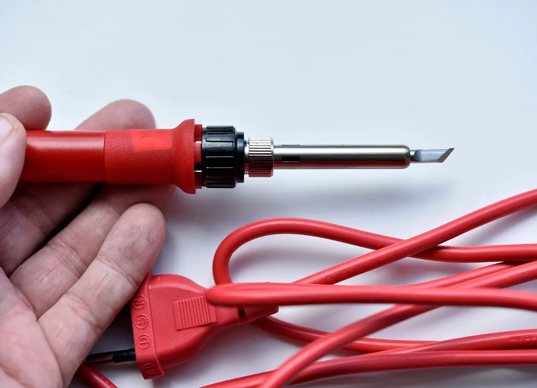 Red soldering iron with attached cord.