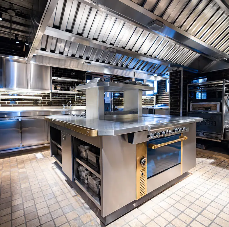 Modern commercial kitchen with stainless steel appliances.