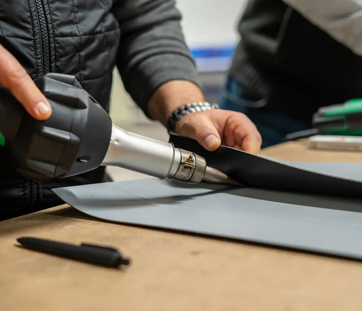 Person using heat gun on fabric material.