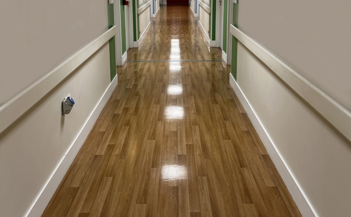 Wooden-floored hallway with white walls.